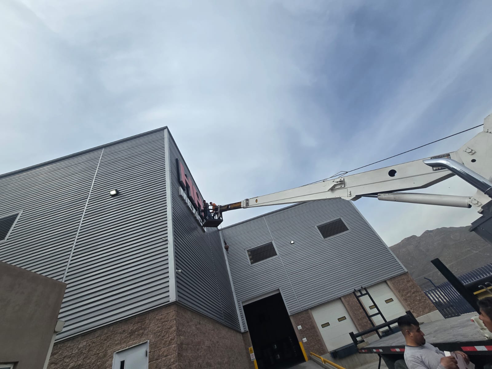 Instalación de fachada comercial con brazo articulado